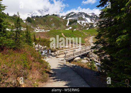 Wunderschöne Aussicht auf eine Spur und eine Brücke über den Fluss durch die Berglandschaft der an einem sonnigen Sommertag umgeben. Im Paradies, Mt Rainier Na genommen Stockfoto