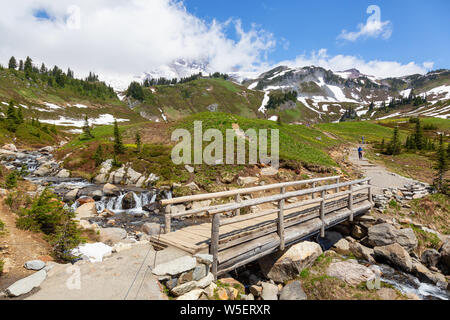 Wunderschöne Aussicht auf eine Spur und eine Brücke über den Fluss durch die Berglandschaft der an einem sonnigen Sommertag umgeben. Im Paradies, Mt Rainier Na genommen Stockfoto