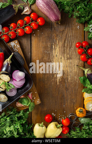 Top view Frame von Gemüse zum Kochen auf dem Grill Pfanne auf einem hölzernen Hintergrund Stockfoto