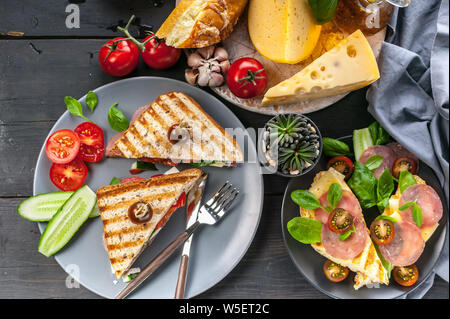 Geräuchertes Rindfleisch Toast, Tomaten, Käse und Spinat. Close-up. Ansicht von oben Stockfoto