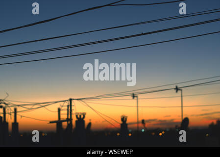 Telefon Kabel, Schornsteine und TV Antennen Silhouette gegen den Himmel am frühen Morgen nur wenige Minuten vor Sonnenaufgang. Stockfoto