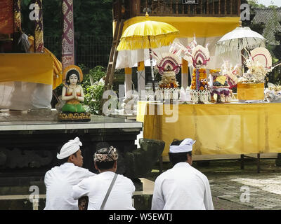 TABANAN, Indonesien - Juni, 16 2017: drei Anhänger sitzen und Anbetung in der Pura Ulun Danu Bratan Tempel, Bali Stockfoto