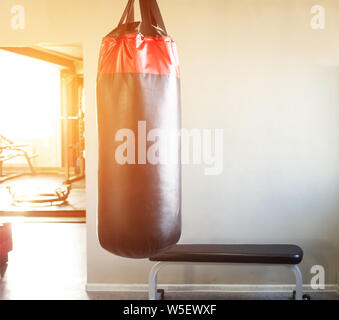 Neue moderne Boxsack in der Halle für Sport und Kampfkunst auf den Hintergrund des Fensters, in dem der Sonnenuntergang, Kopieren, whizzbang Stockfoto