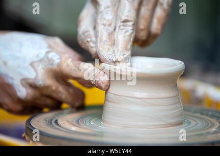 Hände der Potter. Der Töpfer Macht keramik geschirr auf der Töpferscheibe. Der Bildhauer in der Werkstatt macht Lehm Produkt closeup Stockfoto