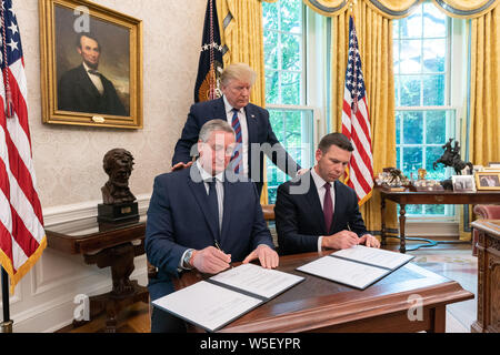 Washington, Vereinigte Staaten von Amerika. 26. Juli, 2019. Präsident Donald J. Trumpf sieht sich als amtierende Sekretär der Homeland Security Kevin McAleenan, rechts, und der Minister des Innern und Inneres von Guatemala Enrique Antonio Degenhart Asturien unterzeichnen eine Vereinbarung über die Zusammenarbeit bei der Prüfung der Schutz Forderungen Freitag, 26. Juli 2019, im Oval Office des Weißen Hauses. Personen: Präsident Donald Trump Credit: Stürme Media Group/Alamy leben Nachrichten Stockfoto