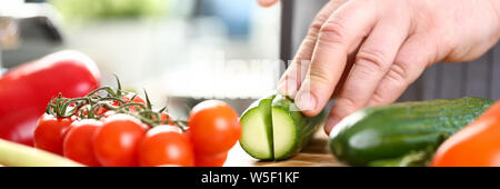 Männliche Hände Schneiden Grün Bio Gurke Foto Stockfoto