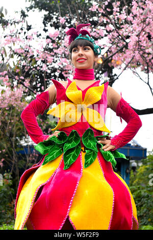 Ein Entertainer gekleidet in einem bunten Rock mit Blumen dekoriert, stellt auf der Guangzhou Chimelong Tourist Resort in der Stadt Guangzhou, Südchina Gua Stockfoto