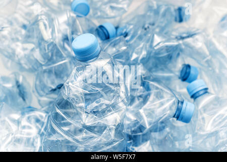 Stapel von komprimierten Plastikflaschen mit blauen Kappen Stockfoto