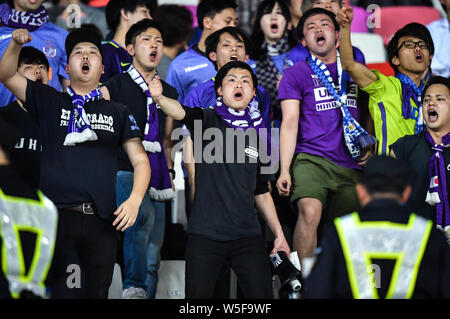 Fans der japanischen Sanfrecce Hiroshima F.C. schreien, um ihre Unterstützung in der Gruppe F gegen China Guangzhou Evergrande Taobao F.C. zeigen während der Stockfoto