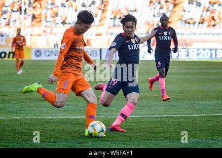 Kazuma Yamaguchi in Japan Kashima Antlers, rechts, versucht einen Schuß von Wang Tong von China Shandong Luneng in Ihrem Team E Achtelfinale block d Stockfoto