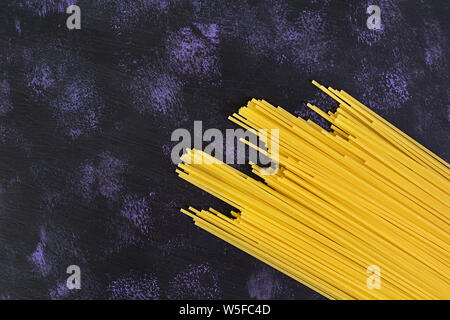 Trockene Teigwaren Hintergrund. Spaghetti Pasta auf dunklem Hintergrund. Flach. Ansicht von oben. Stockfoto