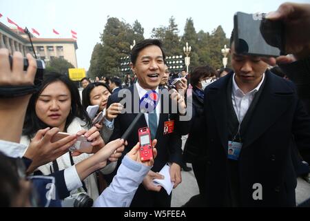 Robin Li Yanhong, Mitte, Vorsitzender und CEO von Baidu, wird von Journalisten umgeben, wie er kommt der Eröffnungsveranstaltung für die zweite Session o zu besuchen Stockfoto
