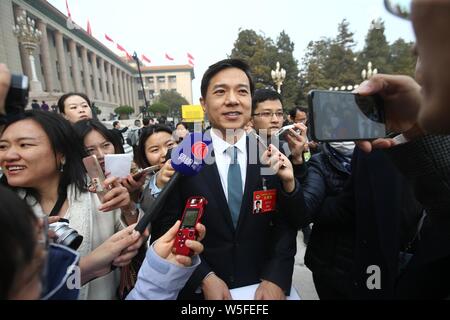 Robin Li Yanhong, Mitte, Vorsitzender und CEO von Baidu, wird von Journalisten umgeben, wie er kommt der Eröffnungsveranstaltung für die zweite Session o zu besuchen Stockfoto