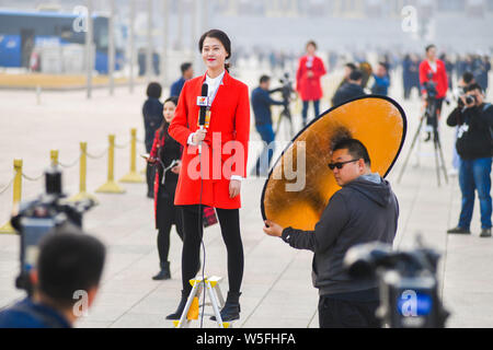 Eine chinesische TV-Journalist macht sie außerhalb der Großen Halle des Volkes bei der Eröffnung der Zweiten Sitzungsperiode des 13. Nationalen C Stockfoto