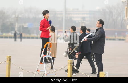 Eine chinesische TV-Journalist macht sie außerhalb der Großen Halle des Volkes bei der Eröffnung der Zweiten Sitzungsperiode des 13. Nationalen C Stockfoto