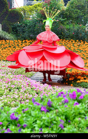 Ein Entertainer gekleidet in einem bunten Rock mit Blumen dekoriert, stellt auf der Guangzhou Chimelong Tourist Resort in der Stadt Guangzhou, Südchina Gua Stockfoto