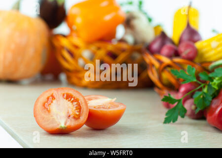 Frisches Gemüse in Weidenkörbe auf dem Holztisch. Stockfoto