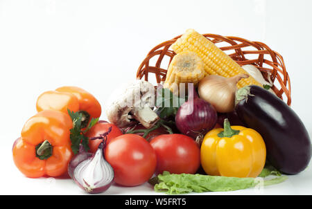 Pilze und eine Vielzahl von frischem Gemüse in einem Weidenkorb. Stockfoto