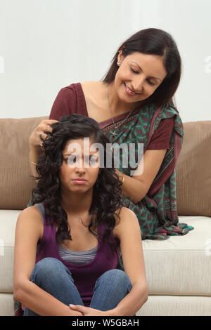 Teenager-Mädchen erhalten Kopfmassage von Mutter Stockfoto