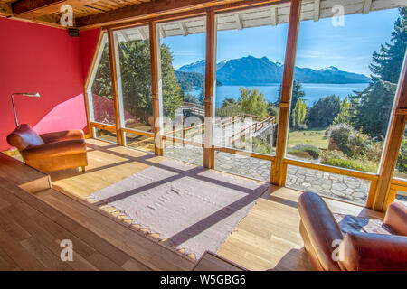 Ein Zimmer mit großen Fenstern mit Blick auf den See in Bariloche Stockfoto