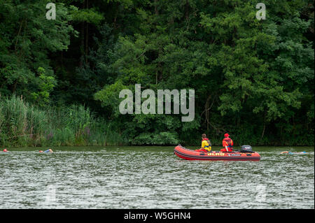 Degenbachsee, Deutschland, 28. Juli 2019. Wasser Retter auf einem Motorboot, Schwimmen Leute während Ilshofen Triathlon. Stockfoto
