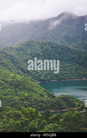 Neblige Landschaft von schönen Tausend Island Lake in Taiwan, China, Asien. See von tiefen tropischen Wald umgeben. Moody Wetter. Retro Vintage, hipster Style. Regenwald. Stockfoto