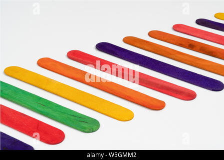 Reihe der farbigen Holzlatten auf eine weiße Fläche Stockfoto