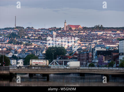 Die Stadt Cork, Cork, Irland. 29. Juli, 2019. Früh Licht beleuchtet die Kirche der Himmelfahrt und Häuser auf der Nordseite der Stadt, während morgen der Verkehr der Michael Collins Brücke in Cork, Irland kreuzt. Kredit; David Creedon/Alamy leben Nachrichten Stockfoto