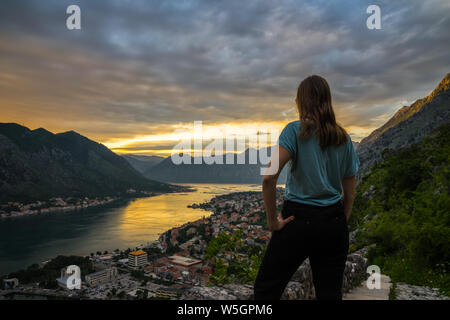Montenegro, hübsche junge blonde Mädchen vor Ort Bucht von Kotor in romantischen orange Sonnenuntergang Dämmerung Stimmung im Sommer Saison Stockfoto