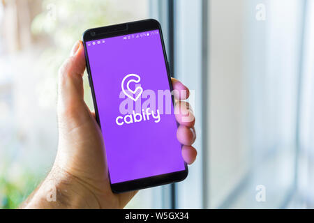 Buenos AIRES, ARGENTINIEN - 19. DEZEMBER 2018: Mann mit Handy mit Cabify-Logo auf dem Bildschirm. Cabify ist eine Smartphone-App zum Mieten von Taxi oder Auto. Inter Stockfoto