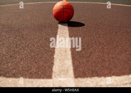 Kugel für Basketball spielen liegt in der Mitte der vertikalen weissen Linie Stockfoto