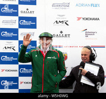 Sir Jackie Stewart winken in die Menge, bevor die Trophäen an die Sieger der FIA Meister historische Formel-1 Rennen, an der 2019 Silverstone Classic Stockfoto