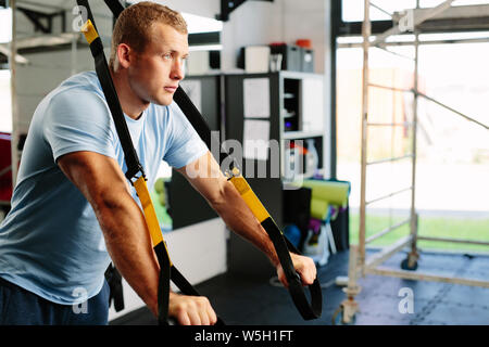 Foto von einem muskulösen Mann tun einer Suspension Training Stockfoto