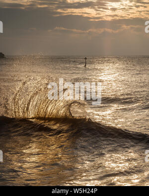 Wellen Gegenlicht der Sonne reflektieren Dawn aus dem Meer an der Wand und die Auswirkungen einer eingehenden, Exmouth, Devon, England, Vereinigtes Königreich, Europa Stockfoto