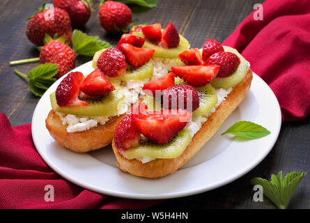 Bruschetta mit Erdbeeren und Kiwis auf Platte Stockfoto