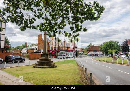 Ein Steinkreuz steht auf einem Grün in der Mitte der Berkshire Dorf Datchet in Großbritannien. Stockfoto