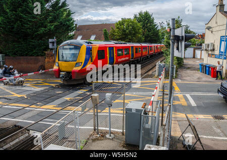 Ein South Western Railway Zug passiert ein Bahnübergang in Datchet in Berkshire, Großbritannien Stockfoto