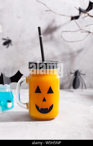 Halloween gesund Kürbis oder Karotte Getränke im Glas auf grauem Hintergrund Stockfoto