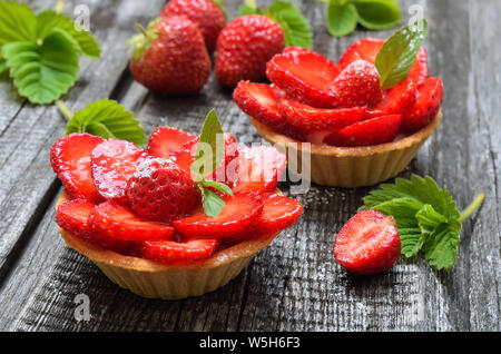Törtchen mit frischen Erdbeeren auf hölzernen Hintergrund Stockfoto