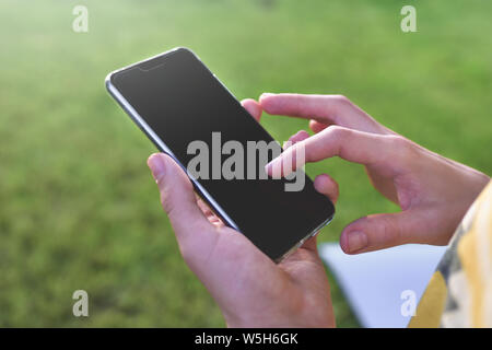 Nahaufnahme der männlichen Händen Text eingeben Nachricht im Freien Stockfoto