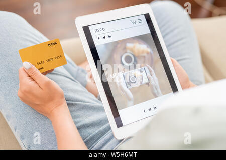 Junge Shopper mit Karte und Touchpad Scrollen durch Waren im Online Shop Stockfoto