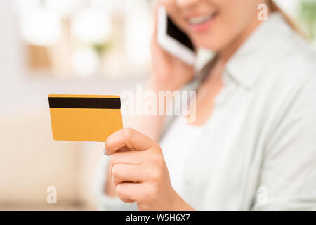 Gelbe Plastikkarte mit schwarzen magnet Linie in der Hand der jungen weiblichen Verbraucher Stockfoto