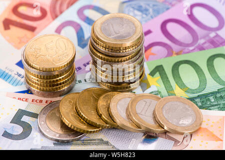 Haufen viele Euro Banknoten mit gestapelten Münzen Stockfoto