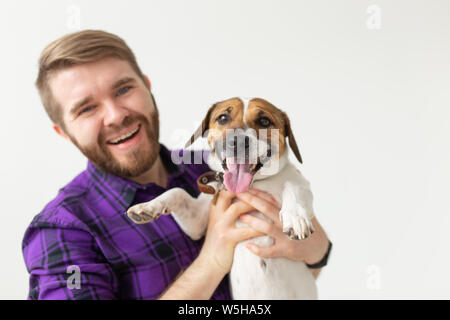 Pet's Owner Konzept - glückliche Mann hält einen Hund Jack Russell Terrier über den weißen Hintergrund Stockfoto