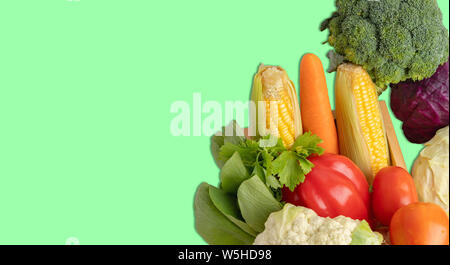 Gruppe Gemüse isoliert. Tomaten und Paprika mit anderen Haufen auf dem grünen Hintergrund. Stockfoto