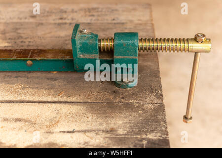Werkstück spannen, Metall tisch Schraubstock auf dem Holz Tisch. Kopieren Sie Platz für Text. Stockfoto
