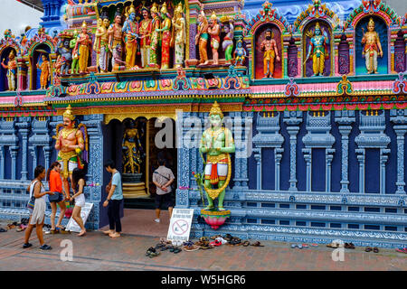 Menschen und Schuhe ausserhalb Sri Krishnan Tempel, ein Hindutempel in Waterloo St Singapur. Schilder an den vorderen Besucher weisen ihre Schuhe zu entfernen. Stockfoto