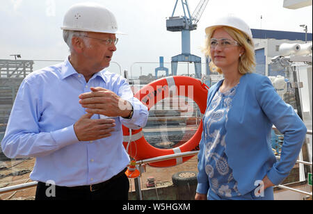 29 Juli 2019, Mecklenburg-Vorpommern, Rostock: Bernard Meyer (L-R), Mitglied der Geschäftsleitung der Meyer Werft Papenburg, informiert in der Neptun Werft Manuela Schwesig (SPD), Ministerpräsident von Mecklenburg-Vorpommern, über den Bau von Flusskreuzfahrtschiffen. Zu Beginn der zweiten Woche der Tour, der Leiter der Regierung widmet sich auf Kreuzfahrt Tourismus. Foto: Bernd Wüstneck/dpa-Zentralbild/dpa Stockfoto