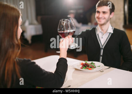 Schöne junge Paar mit Gläser Rotwein in Luxus Restaurant Stockfoto