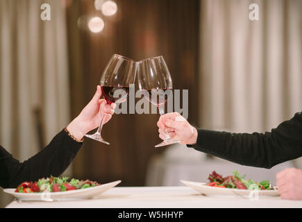 Mann und Frau trinkt Rotwein. Im Bild, close-up Hände mit Brille. Stockfoto